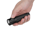 Hand holding black tactical flashlight with green button