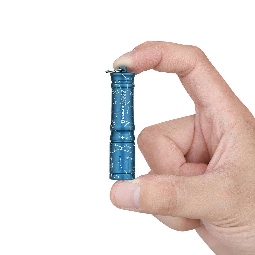 Olight Blue I3E EOS keychain flashlight with constellation pattern held by fingers, for everyday carry.