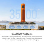 Orange rechargeable flashlight, 3500mAh battery, 6+ days runtime, on rocks by lake, mountains, blue sky