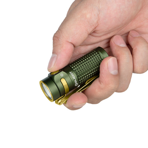 Olight olive green Baton 4 Premium flashlight held in hand, showcasing textured body and gold pocket clip for EDC.